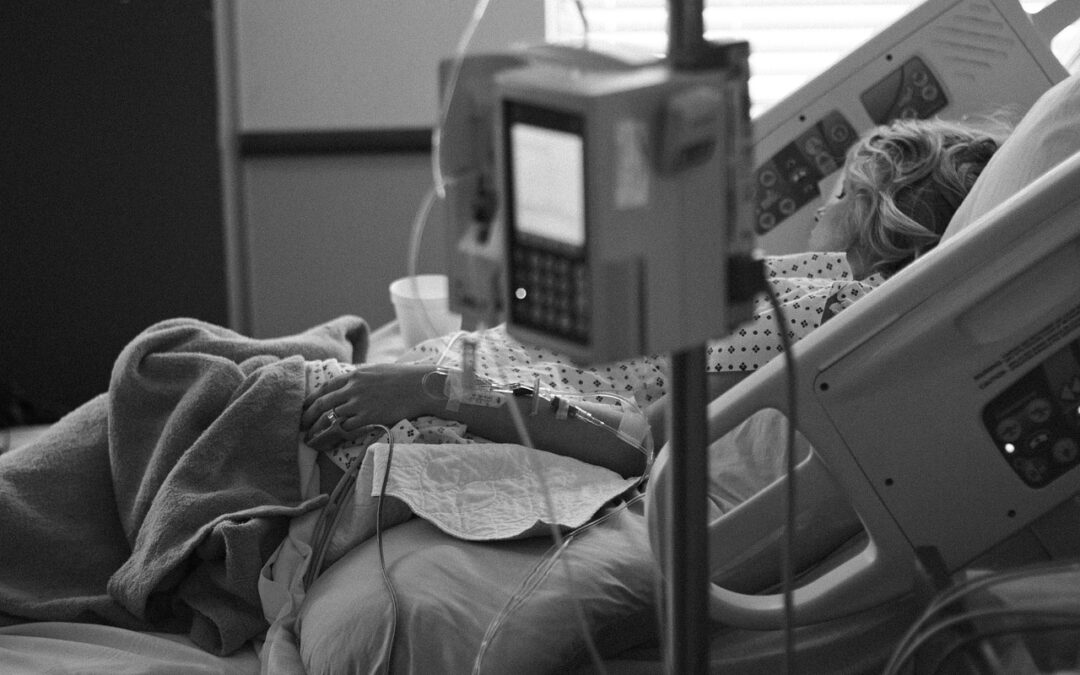 Women lying in hospital bed.